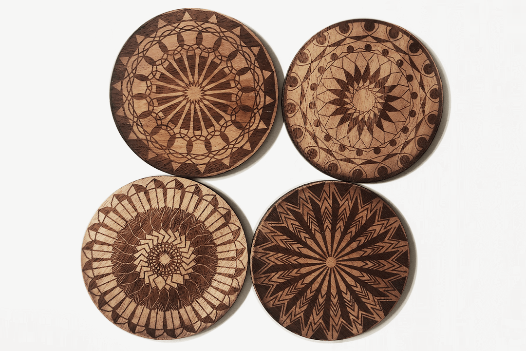 Photo of wooden coasters that have been laser cut and engraved with intricate geometric patterns