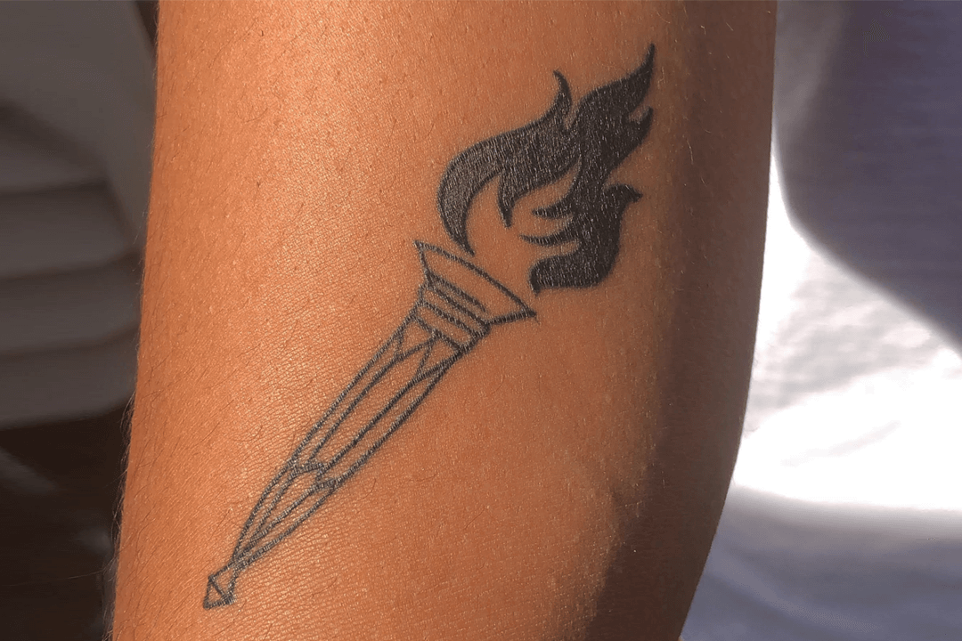 Photo taken of a minimalist torch tattoo on an arm