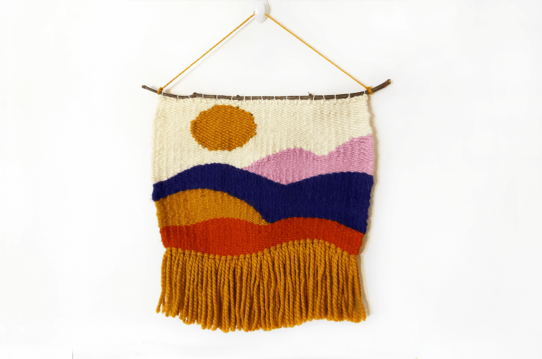 photo of a woven wall hanging that looks like an abstract sunset
